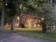 Two-story home with a brick chimney and outdoor lighting, surrounded by mature trees and a green lawn at 11510 Ralston Ave, Carmel, IN 46032