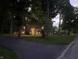 Two-story home with a brick chimney and outdoor lighting, surrounded by mature trees and a green lawn at 11510 Ralston Ave, Carmel, IN 46032