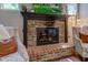 Close-up of a brick fireplace with a dark wood mantle and comfortable seating on either side at 11510 Ralston Ave, Carmel, IN 46032