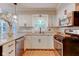 Bright kitchen featuring white cabinetry, a stainless steel dishwasher, and a garden view window at 11510 Ralston Ave, Carmel, IN 46032