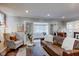 Inviting living room featuring a leather sofa, cozy armchair, fireplace, and an open entryway at 11510 Ralston Ave, Carmel, IN 46032