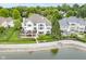 Aerial view of a home with a lake view, patio and lush backyard at 12192 Woods Bay Pl, Carmel, IN 46033