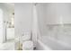Bright bathroom featuring a toilet, bathtub with shower curtain, and an adjacent vanity area at 12192 Woods Bay Pl, Carmel, IN 46033