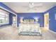 Large bedroom featuring blue walls, a ceiling fan, and large windows at 12192 Woods Bay Pl, Carmel, IN 46033