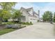 Spacious driveway leads to a stone home with a three-car garage and manicured gardens at 12192 Woods Bay Pl, Carmel, IN 46033