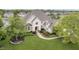 Aerial view of a stately brick home with lush landscaping, manicured lawn, and mature trees at 12192 Woods Bay Pl, Carmel, IN 46033