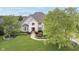 Aerial view of a stately brick home with lush landscaping, a manicured lawn, and mature trees at 12192 Woods Bay Pl, Carmel, IN 46033