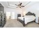 Main bedroom featuring a tray ceiling, fan, and two dressers at 12192 Woods Bay Pl, Carmel, IN 46033