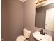 Compact half bathroom features a round sink with dark fixture, toilet, and a mirror at 12671 Endurance Dr, Fishers, IN 46037