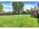Spacious back yard features a large grassy area, mature trees, and a storage shed at 13172 E 116Th St, Fishers, IN 46037