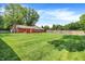 Expansive back yard features a red brick home, lush lawn, mature trees, and a wooden privacy fence at 13172 E 116Th St, Fishers, IN 46037