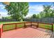 Spacious back yard has a lush lawn, a red deck with a built-in bench, and mature trees at 13172 E 116Th St, Fishers, IN 46037