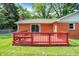 Red brick home features a red deck, green lawn and mature trees in the expansive back yard at 13172 E 116Th St, Fishers, IN 46037