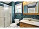 Bathroom featuring blue wallpaper, a glass-enclosed shower, a wooden vanity, and a window at 13172 E 116Th St, Fishers, IN 46037
