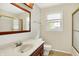 Bright bathroom with a wood vanity, white sink, and large mirror, complemented by neutral walls and natural light at 13172 E 116Th St, Fishers, IN 46037