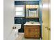 Bathroom featuring blue wallpaper, a wooden vanity with a white countertop, and a window for natural light at 13172 E 116Th St, Fishers, IN 46037