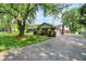 A ranch-style home with attached garage and a long driveway surrounded by mature trees and landscaping at 13172 E 116Th St, Fishers, IN 46037
