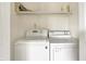 Bright laundry room features a modern washer and dryer, plus a shelf for storage at 13172 E 116Th St, Fishers, IN 46037