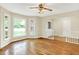 Sun-filled living area with hardwood floors, a ceiling fan, and large bay windows at 13172 E 116Th St, Fishers, IN 46037