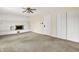 Open living space with white-painted brick fireplace, carpeting, and a double-door closet at 13172 E 116Th St, Fishers, IN 46037