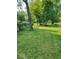 Spacious backyard with green grass and mature trees, offering a serene outdoor space at 1322 Greenway Dr, Anderson, IN 46011