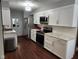 Modern kitchen featuring white cabinets, stainless steel appliances, and wood look flooring at 1322 Greenway Dr, Anderson, IN 46011