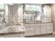 Bright bathroom featuring granite countertops, dual sinks, and white cabinets at 140 4Th Nw St, Carmel, IN 46032