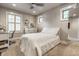 Cozy bedroom with neutral colors, a ceiling fan, a white bed, and a white desk with chair by the window at 140 4Th Nw St, Carmel, IN 46032