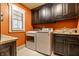 Bright laundry room with modern washer and dryer, granite countertops, and custom cabinetry at 140 4Th Nw St, Carmel, IN 46032
