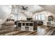 Open-concept living room with hardwood floors, a ceiling fan, a day bed, and a game area at 140 4Th Nw St, Carmel, IN 46032