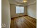Bedroom featuring wood-look flooring, a window, white walls, and recessed ceiling at 1421 S Meridian St, Indianapolis, IN 46225