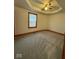 Carpeted bedroom featuring a tray ceiling, fan, window and wood trim at 1421 S Meridian St, Indianapolis, IN 46225