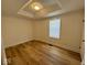 Bedroom with recessed ceiling, wood-look flooring, a window, and white walls at 1421 S Meridian St, Indianapolis, IN 46225