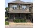 Two-story home with front porch featuring brick accents, gray siding and roofing, and traditional windows at 1421 S Meridian St, Indianapolis, IN 46225