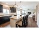 Open concept kitchen with white island, granite countertops, dark cabinets and breakfast bar seating at 14514 Glapthorn Rd, Fishers, IN 46037