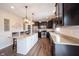 Bright kitchen with a white island, dark cabinets, stainless steel appliances and stylish pendant lighting at 14514 Glapthorn Rd, Fishers, IN 46037