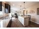 Well-lit kitchen with island, granite countertops, dark cabinetry, and an open view into the living area at 14514 Glapthorn Rd, Fishers, IN 46037