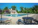 Community pool and clubhouse surrounded by mature trees and lounging furniture at 14514 Glapthorn Rd, Fishers, IN 46037