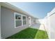 Fenced backyard features a small lawn and patio area with home's gray siding at 1452 Coen Ct, Columbus, IN 47201