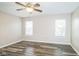 Bright bedroom featuring a modern ceiling fan, plank flooring, and natural light from two large windows at 14911 Silver Thorne Way, Carmel, IN 46033