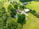 Aerial view of the property featuring a pool, lush greenery, and outbuildings at 15812 Joliet Rd, Westfield, IN 46074