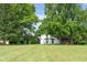 Sprawling front yard and two-story home with dark trim surrounded by mature trees at 15812 Joliet Rd, Westfield, IN 46074
