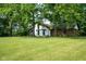 Mature trees surround this house with manicured lawn and neutral colored brick and siding at 15812 Joliet Rd, Westfield, IN 46074