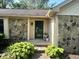 Charming front entrance featuring a stone facade, verdant landscaping, and a welcoming green front door at 177 Wellington Pkwy, Noblesville, IN 46060