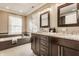 Bathroom with a double sink vanity, granite countertops, and a large soaking tub by the window at 2016 Central Ave, Indianapolis, IN 46202