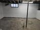 This is an unfinished basement with painted white walls, exposed duct work, and a single window at 2035 S Pennsylvania St, Indianapolis, IN 46225