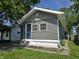 Charming single-story home featuring gray siding, a blue front door, and a well-maintained lawn under a sunny sky at 2035 S Pennsylvania St, Indianapolis, IN 46225