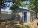 A detached garage featuring gray siding and a vibrant blue door, complemented by a verdant lawn at 2035 S Pennsylvania St, Indianapolis, IN 46225