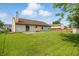 Spacious backyard with lush green grass, concrete patio, and play structure, perfect for outdoor activities at 2145 W Autumn Ln, Columbus, IN 47201
