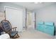 Bright bedroom with a rocking chair, closet with folding doors, and block toys at 2145 W Autumn Ln, Columbus, IN 47201